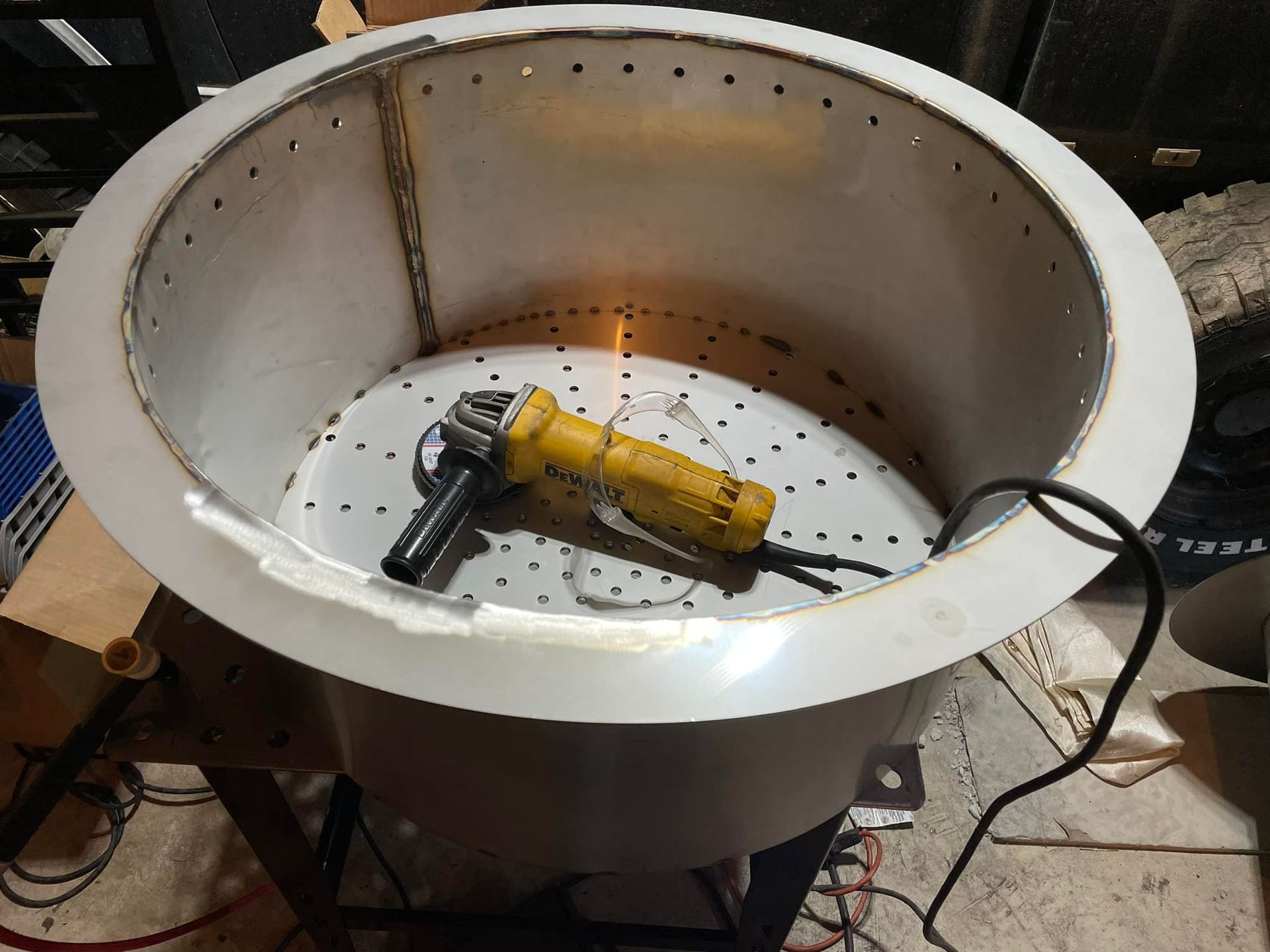 A yellow grinder is sitting inside of a large metal container