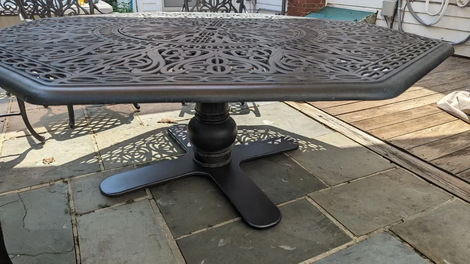 A table with a black base is sitting on a patio