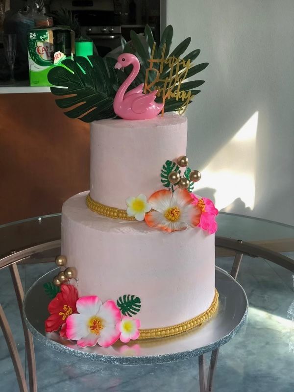 A pink cake with a flamingo on top of it