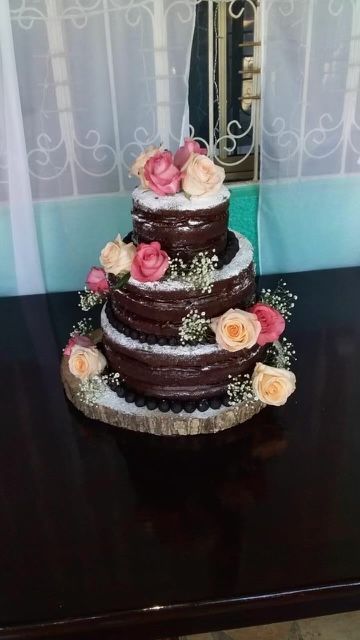 A chocolate cake with flowers on top is sitting on a table.