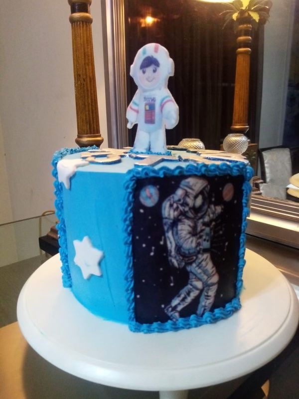 A blue cake with an astronaut on top of it