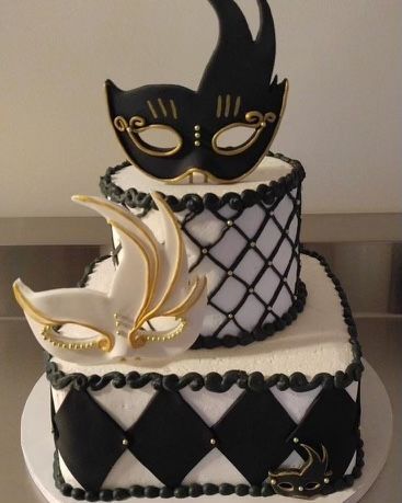 A black and white cake with a cat mask on top