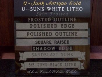 A granite sample display board showing various lettering, outline, and finish styles for headstone inscriptions.