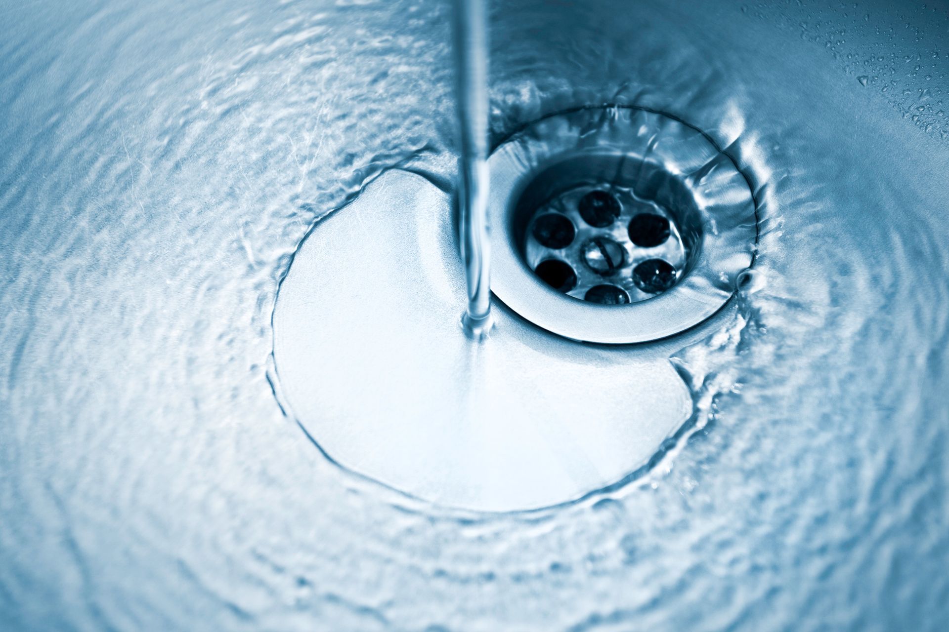 Water going down kitchen sink drain.