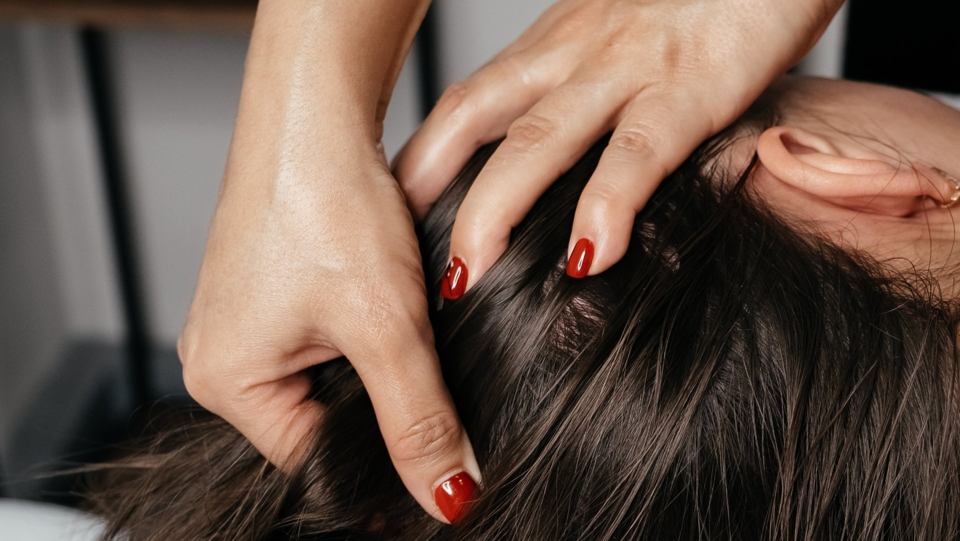 Close-up view of two well-manicured hands giving a head massage