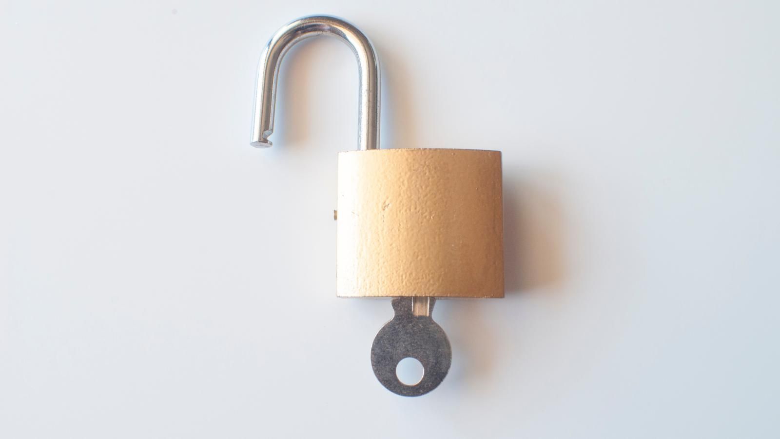 An open padlock with a key attached to it.