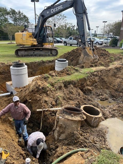 A deere excavator is digging a hole in the ground.