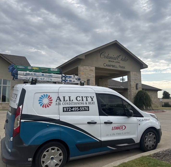 An all city van is parked in front of a building