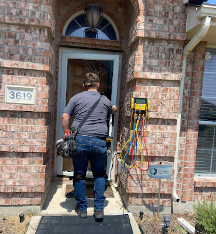 A man standing in front of a brick house with the number 3639 on it