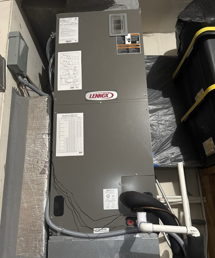 A lennox air conditioner is sitting on the side of a building