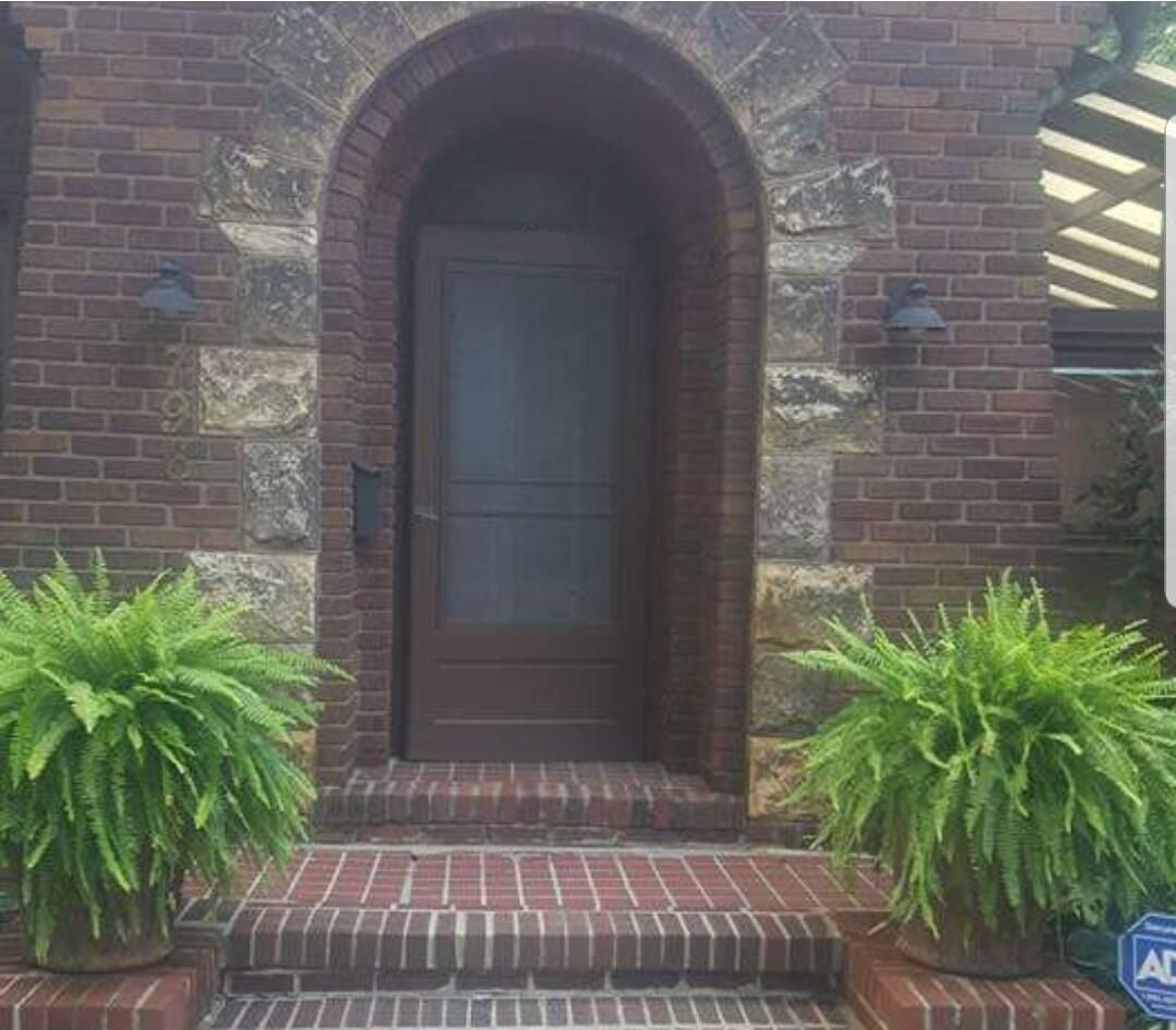 Front door to a beautiful home with aged bricks in need of restoration