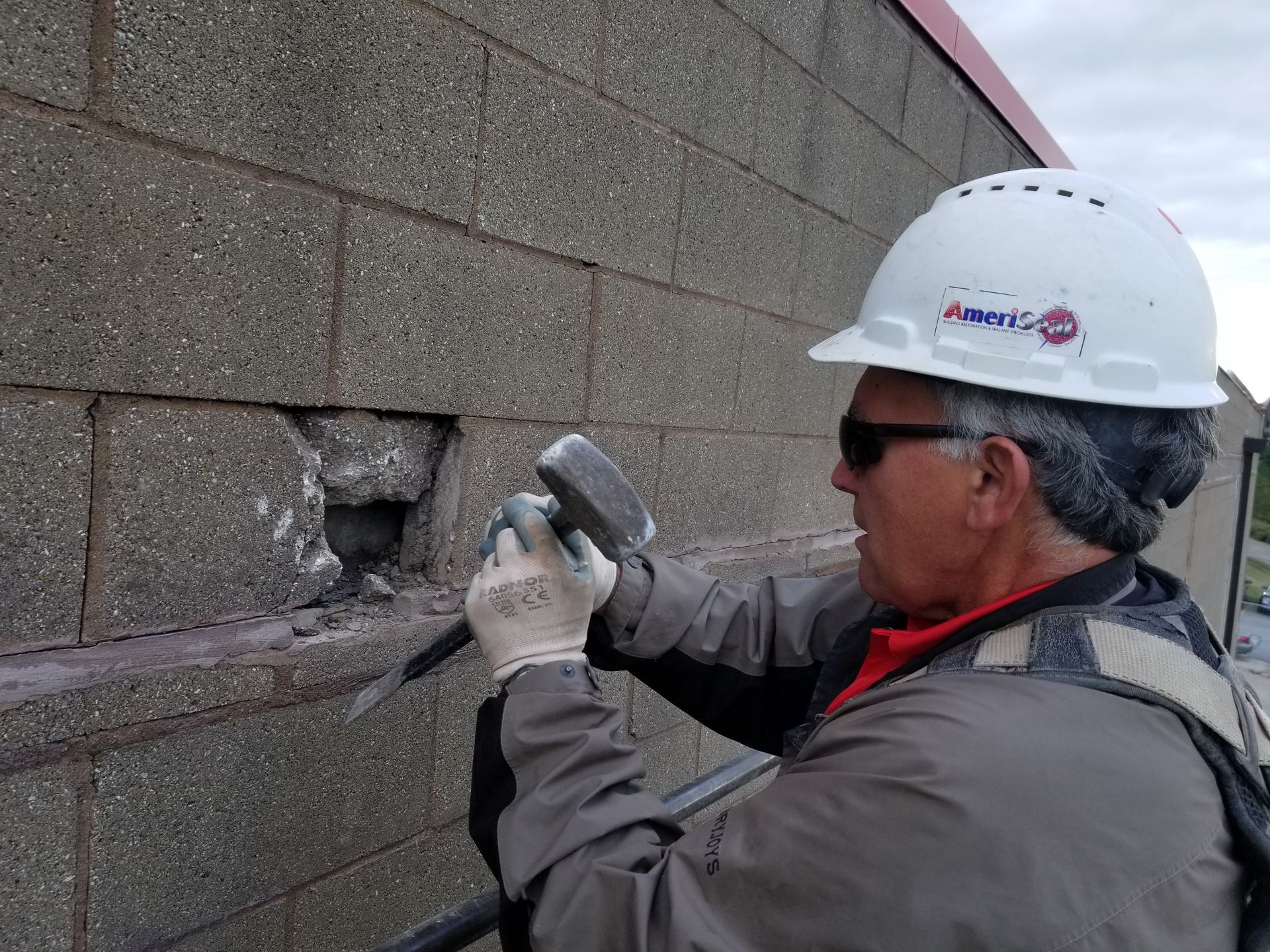 Ameriseal team member removing and replacing cracked stone in a wall