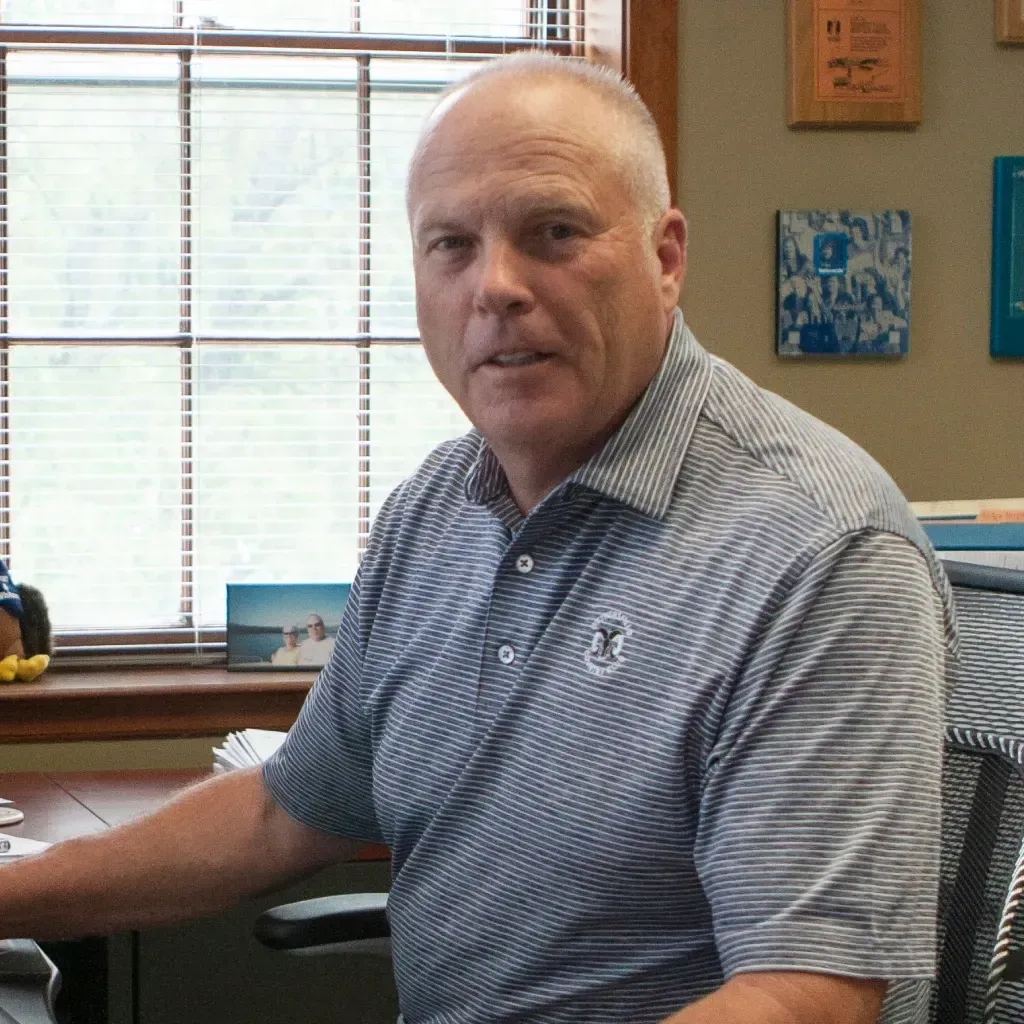 A man wearing a striped shirt with the letter m on it