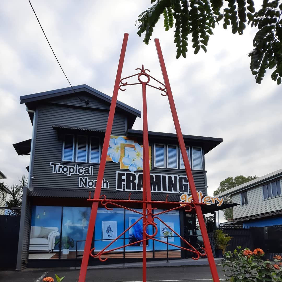 Red Easel in Front of a Two-story Building for Tropical North Framing — Tropical North Framing Gallery Cairns in Cairns, QLD
