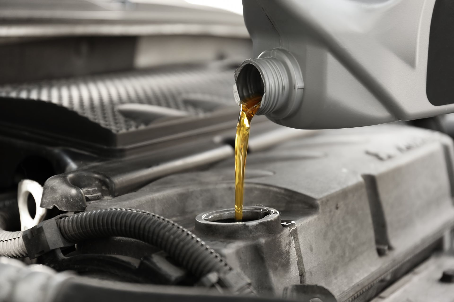 Pouring oil into a car engine, filling the oil reservoir.