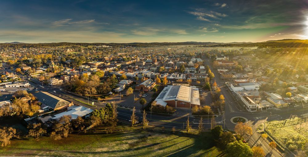 An Aerial View of a City at Sunset With the Sun Shining Through the Clouds — Bellarine Removals In Highton, VIC