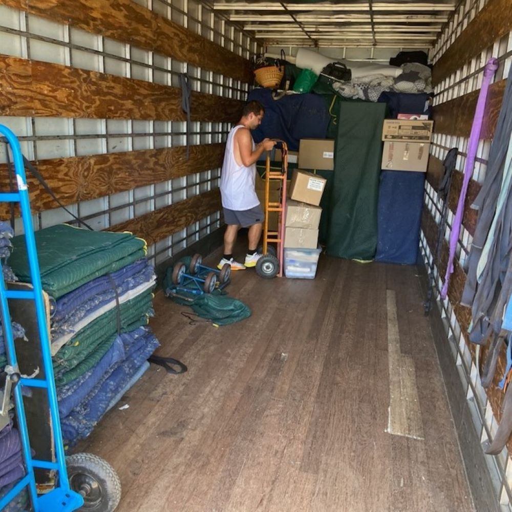 A Man is Standing in the Back of a Moving Truck — Bellarine Removals In Highton, VIC