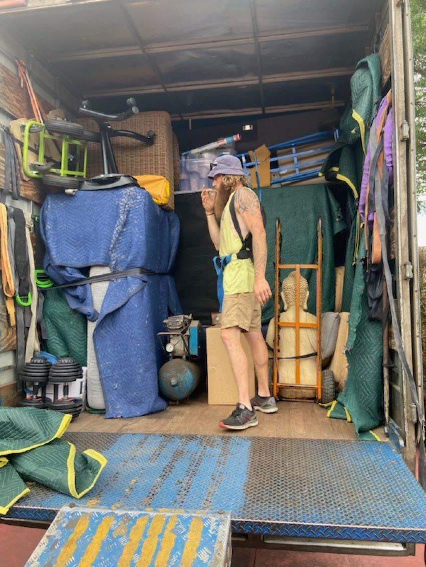A Man is Standing in the Back of a Truck — Bellarine Removals In Geelong, VIC