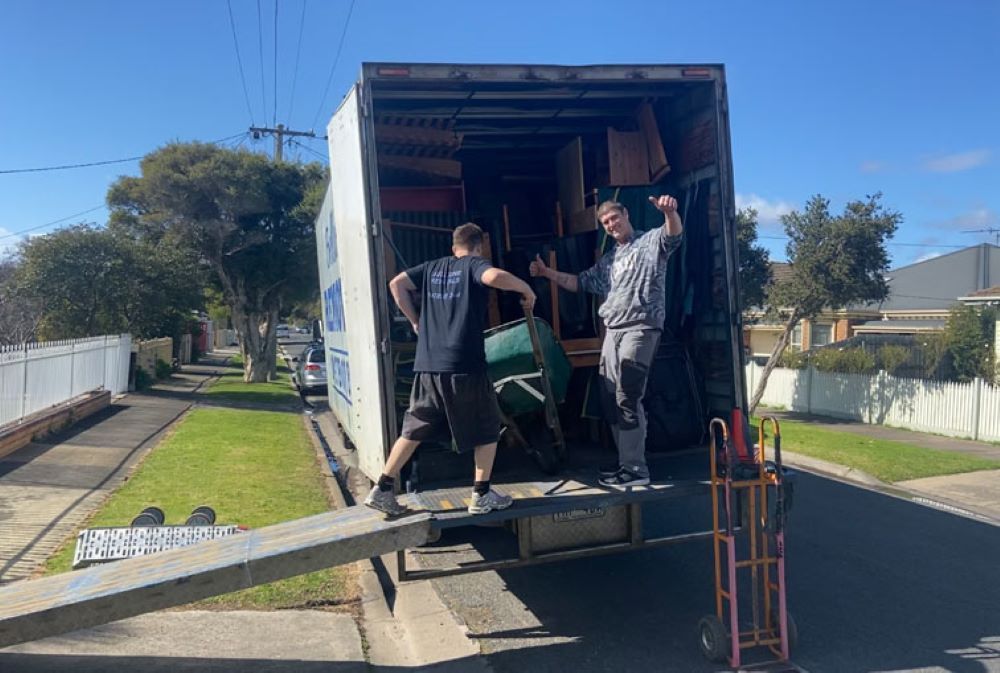 Two Men Are Loading Furniture Into a Moving Truck — Bellarine Removals In Geelong, VIC