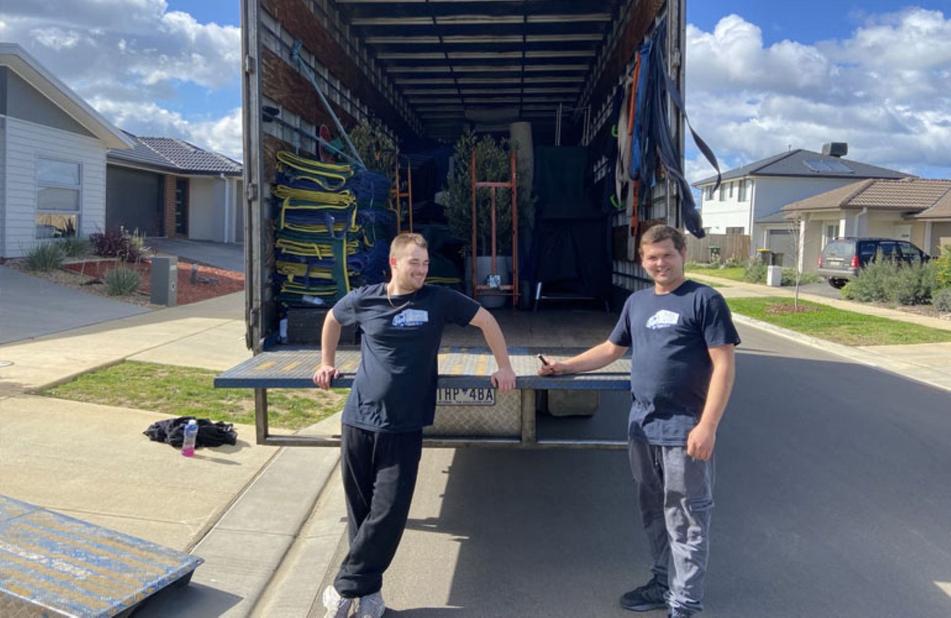 A Man in a Black Shirt is Holding a Piece of Wood — Bellarine Removals In Geelong, VIC