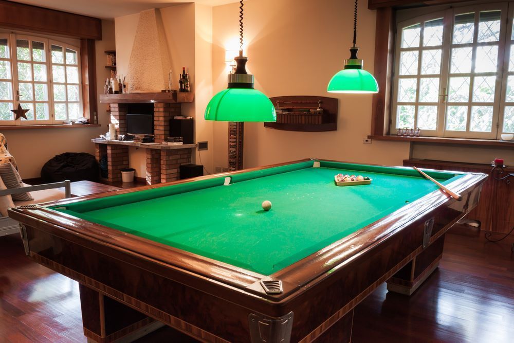 A Pool Table in a Living Room With Green Lights Hanging From the Ceiling — Bellarine Removals In Geelong, VIC