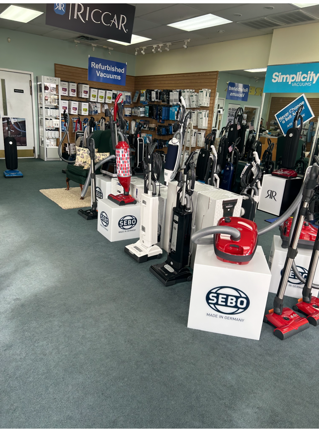 Vacuum cleaner store with many upright and canister models on display.