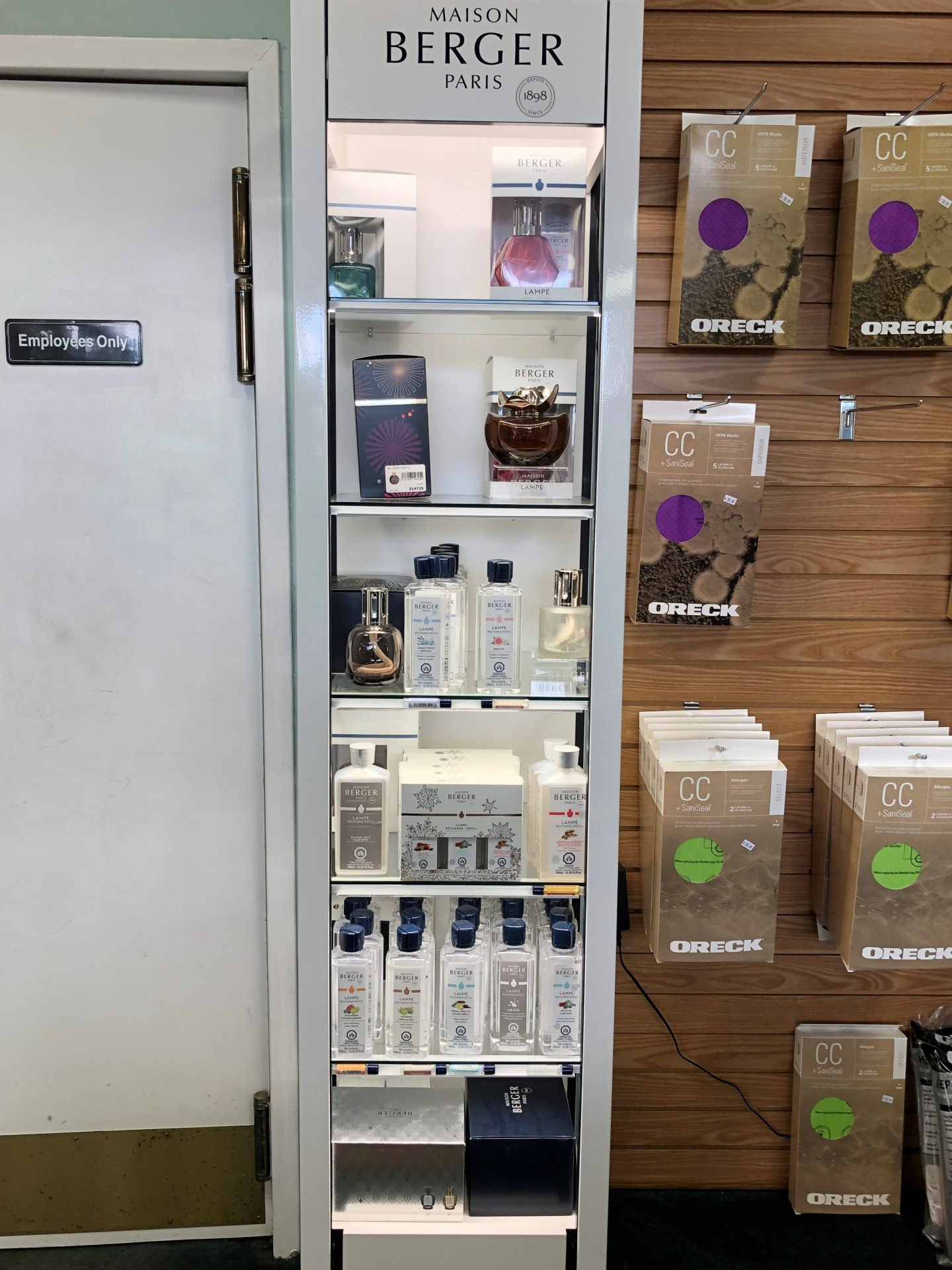 Tall, illuminated display case with various products. 