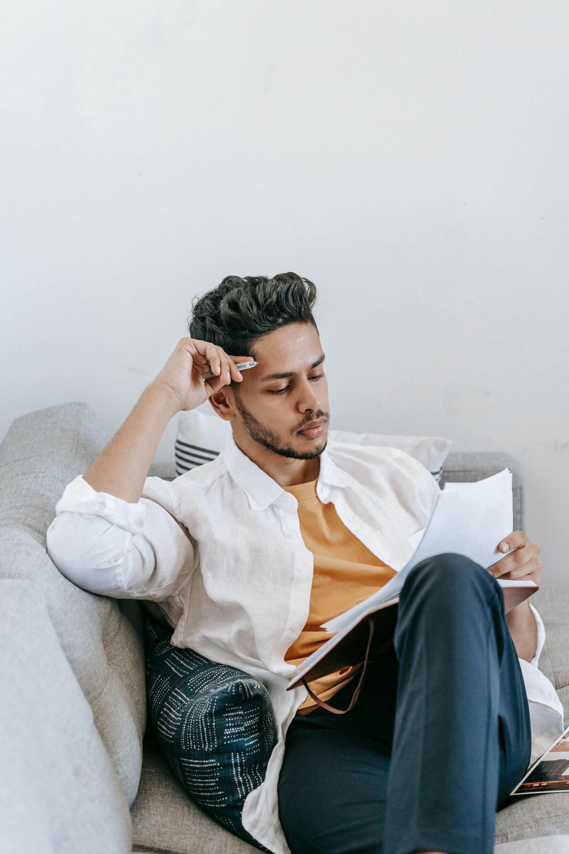 A man and a woman are sitting on a couch talking to each other.