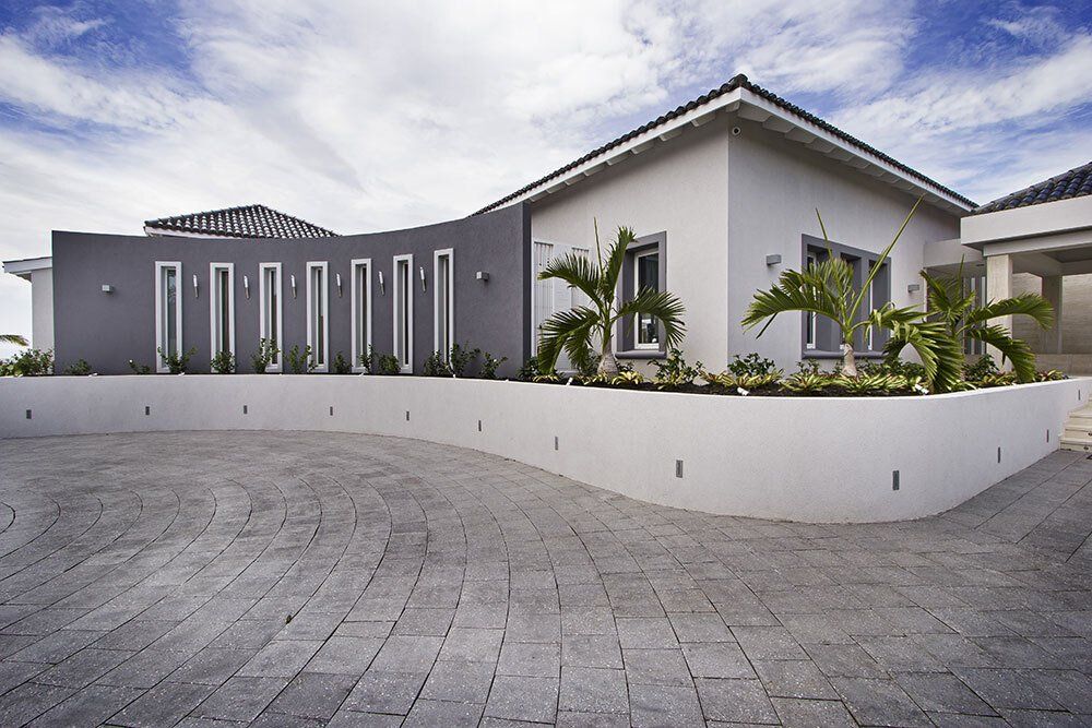 A large white house with a curved driveway in front of it