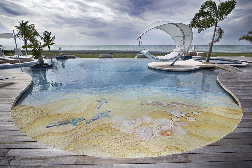 A large swimming pool with a sandy beach design on the floor