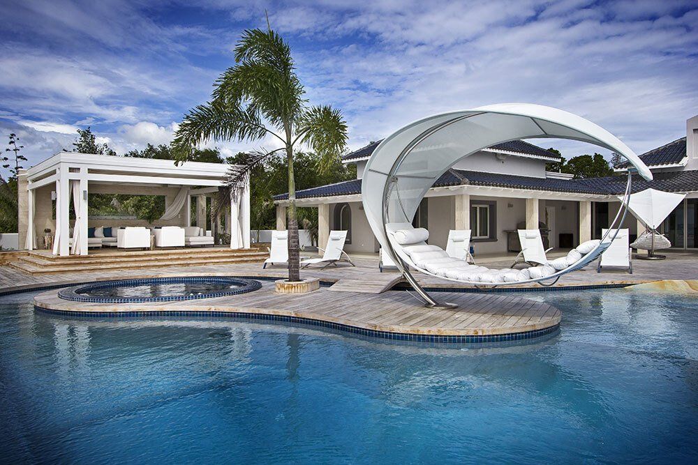There is a large swimming pool in front of a house.