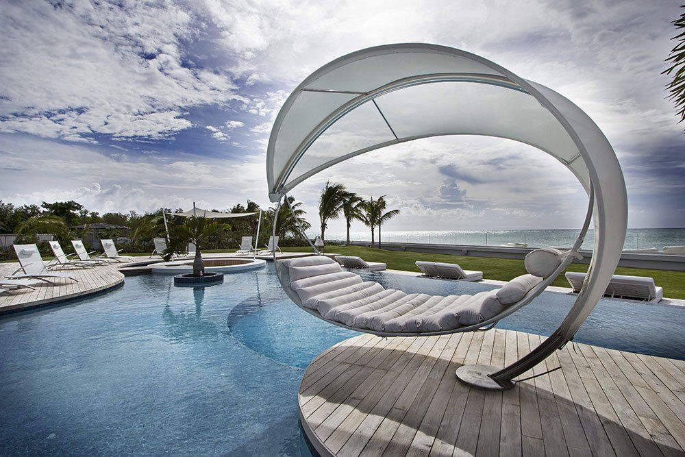 A large swimming pool surrounded by chairs and umbrellas
