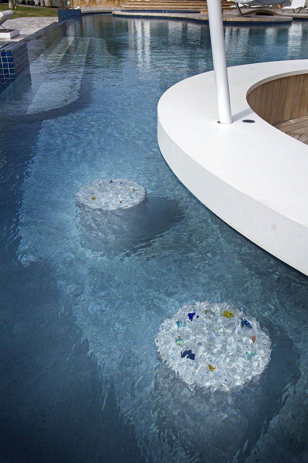 A swimming pool with a circular bar in the middle of it.