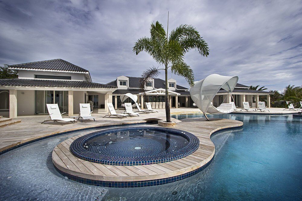 A large house with a swimming pool in front of it