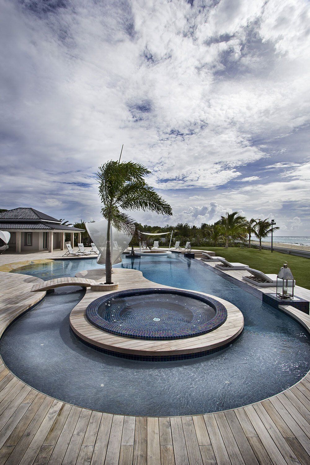 A large swimming pool with a hot tub in the middle