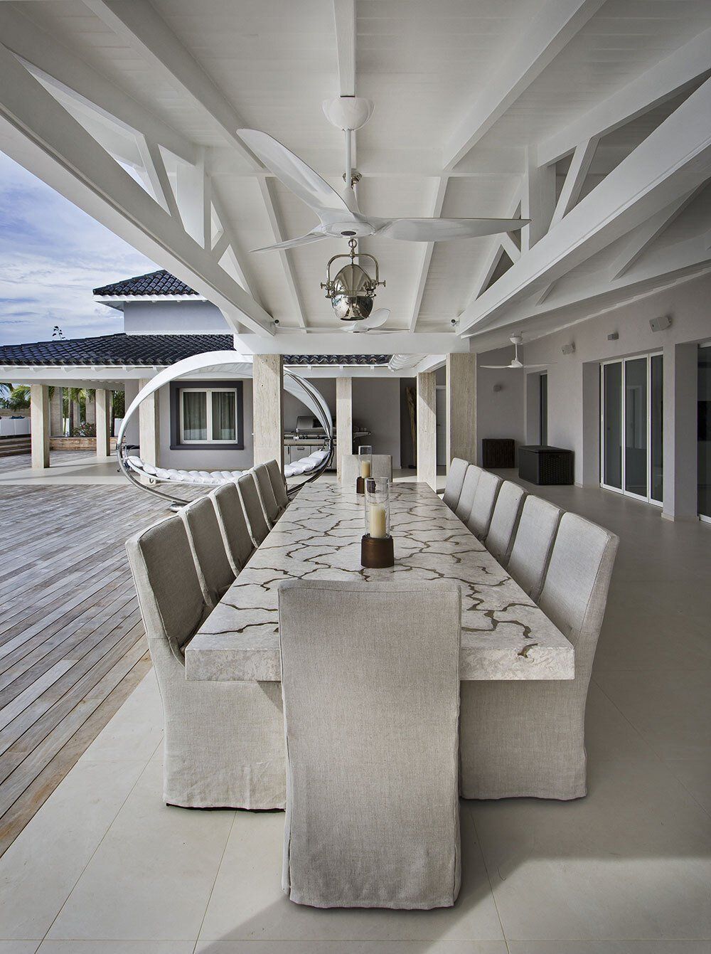 A long table with chairs under a ceiling fan