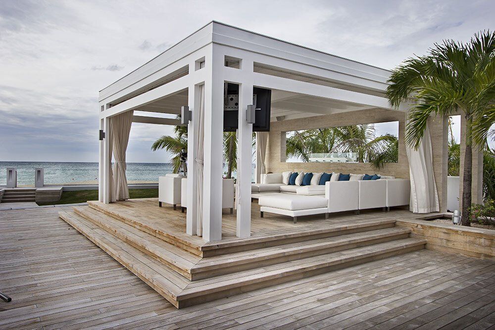 A white gazebo with a couch underneath it