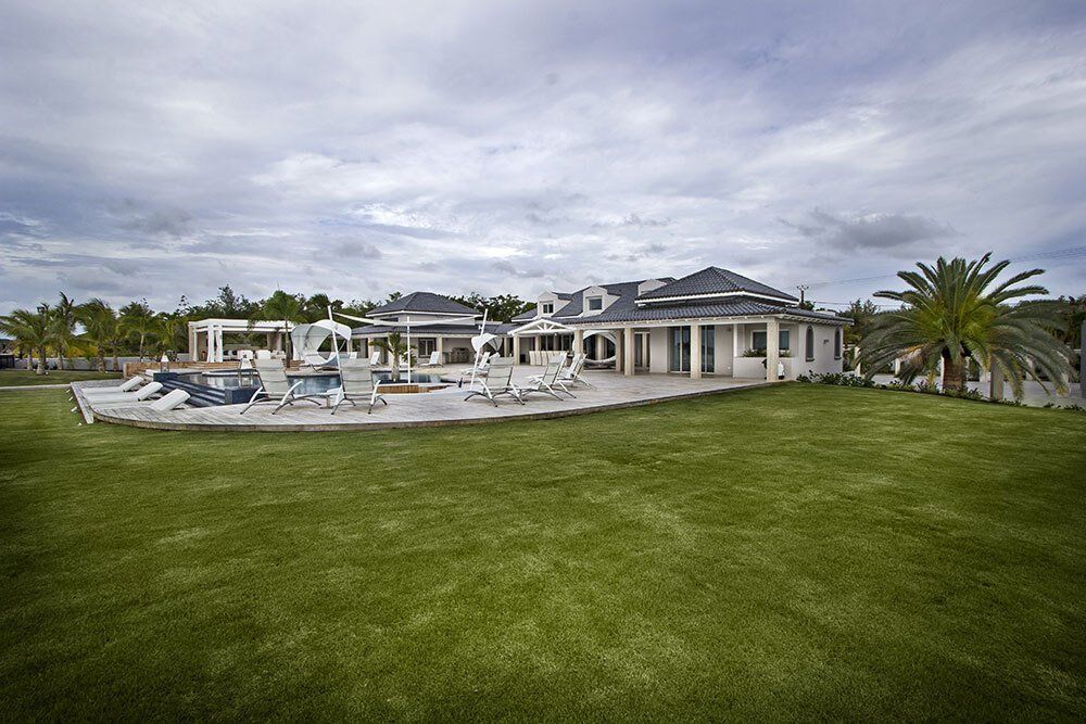 A large white house with a large lawn in front of it.