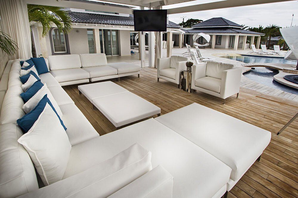 A living room with white furniture and a flat screen tv