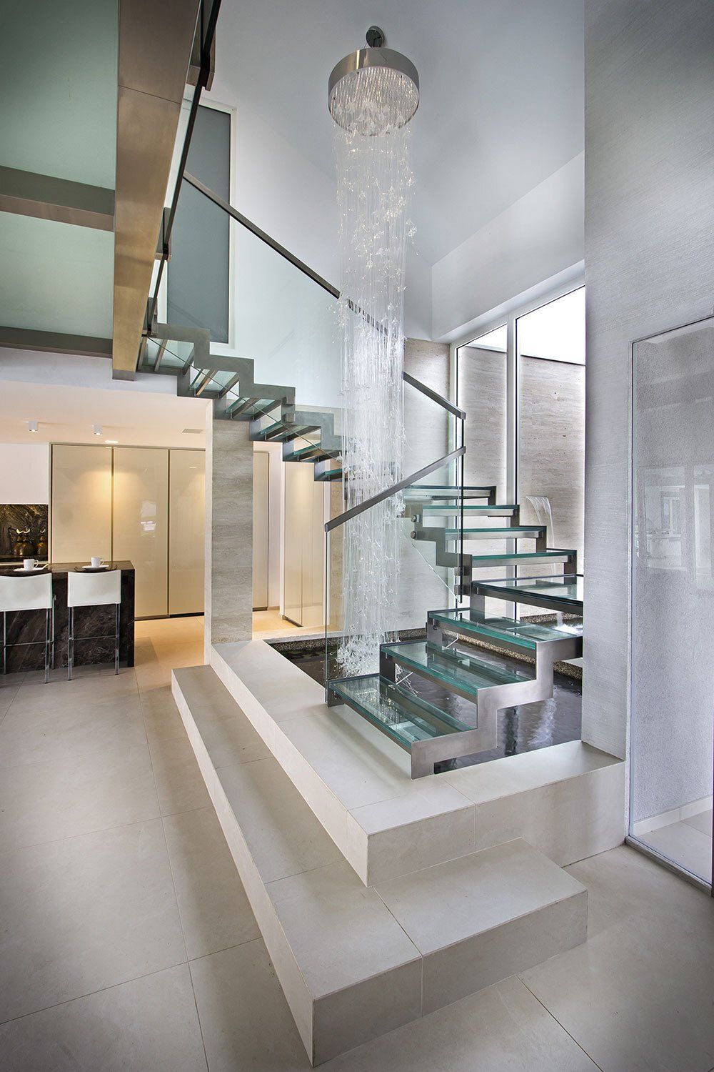 A modern staircase with a glass railing in a house.