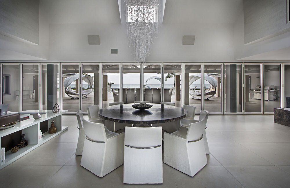 A dining room with a round table and white chairs