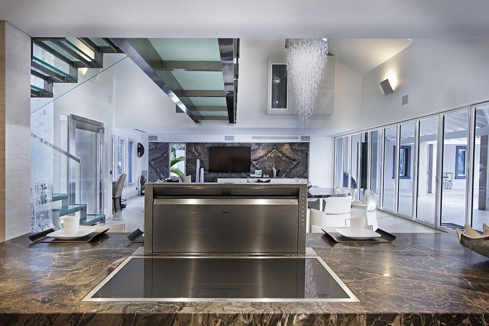 A kitchen with a stove top oven and a marble counter top
