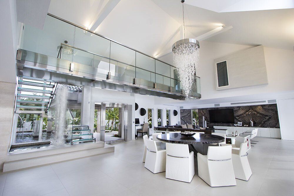 A dining room with a table and chairs and a chandelier hanging from the ceiling