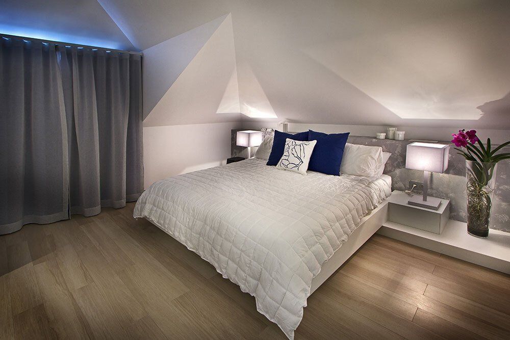A bedroom with a white bed and blue pillows