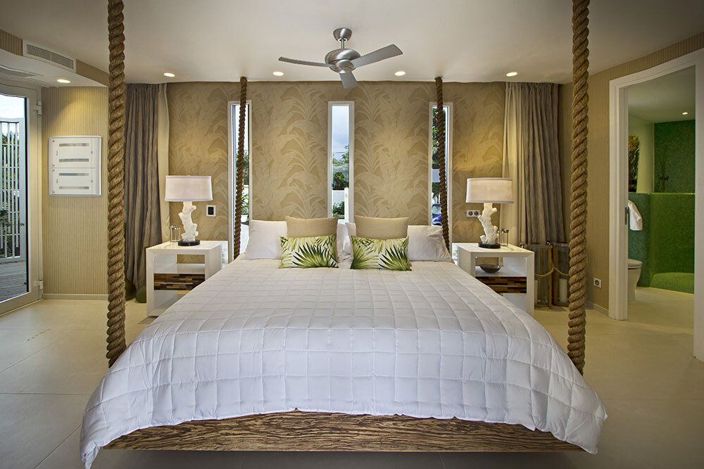 A bedroom with a four poster bed and a ceiling fan.