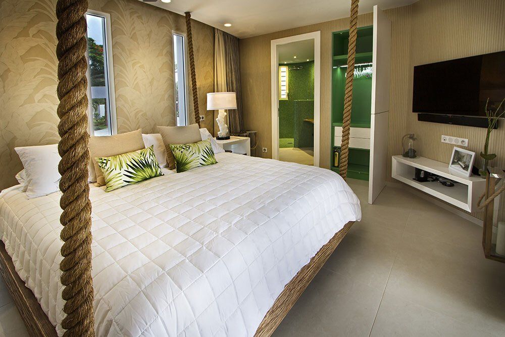 A bedroom with a rope bed and a flat screen tv