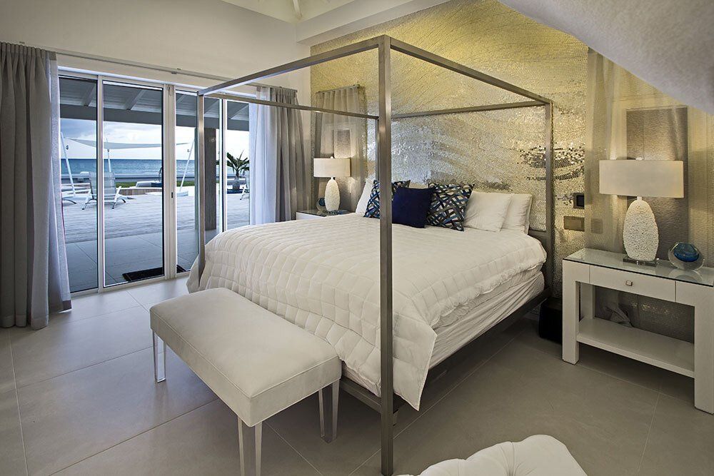 A bedroom with a four poster bed and sliding glass doors