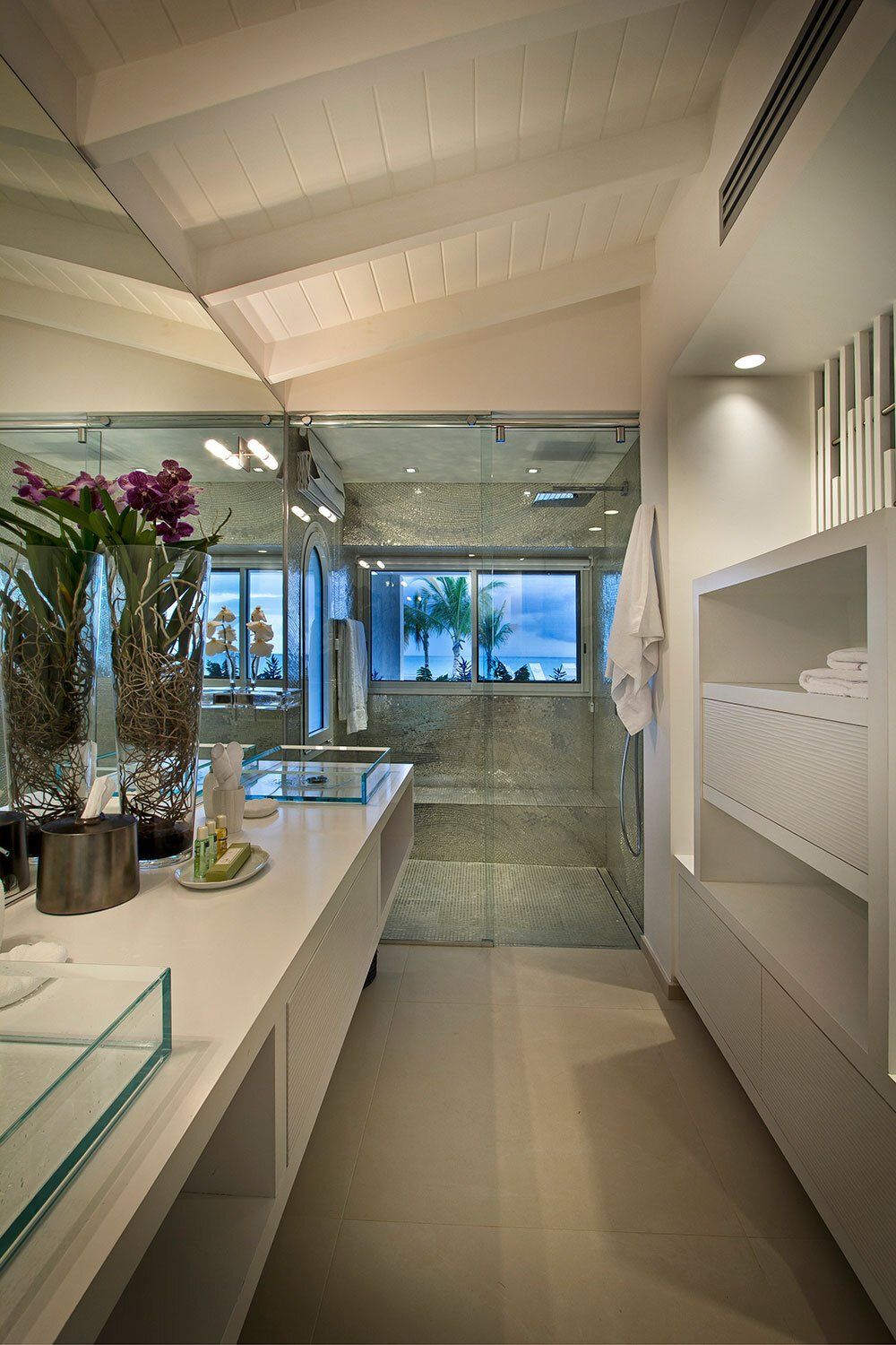 A bathroom with a walk in shower and a sink
