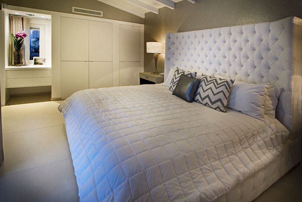 A bedroom with a king size bed and a tufted headboard