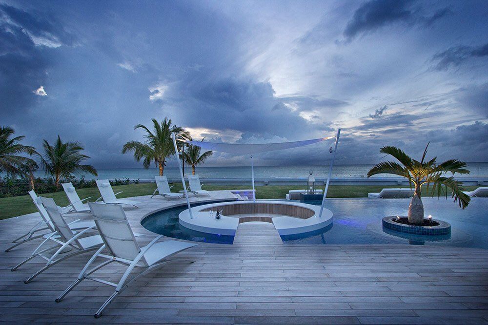 There is a swimming pool with a hot tub in the middle of it.
